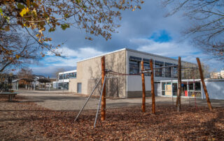 Blick auf die Turnhalle aus der hinteren Ecke des Schulhofs