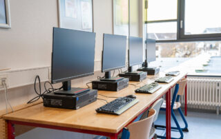 Computerraum mit vielen Bildschirmen und Tastaturen