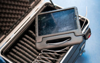 Ein offener Koffer mit vielen Geräten und Kabeln steht im Klassen Raum