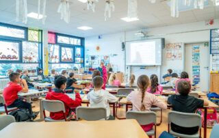 Kinder im Klassenraum mit Blick zur Tafel