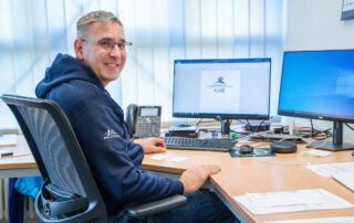 Rektor Himmelsbach schaut lachend in die Kamera am Arbeitsplatz