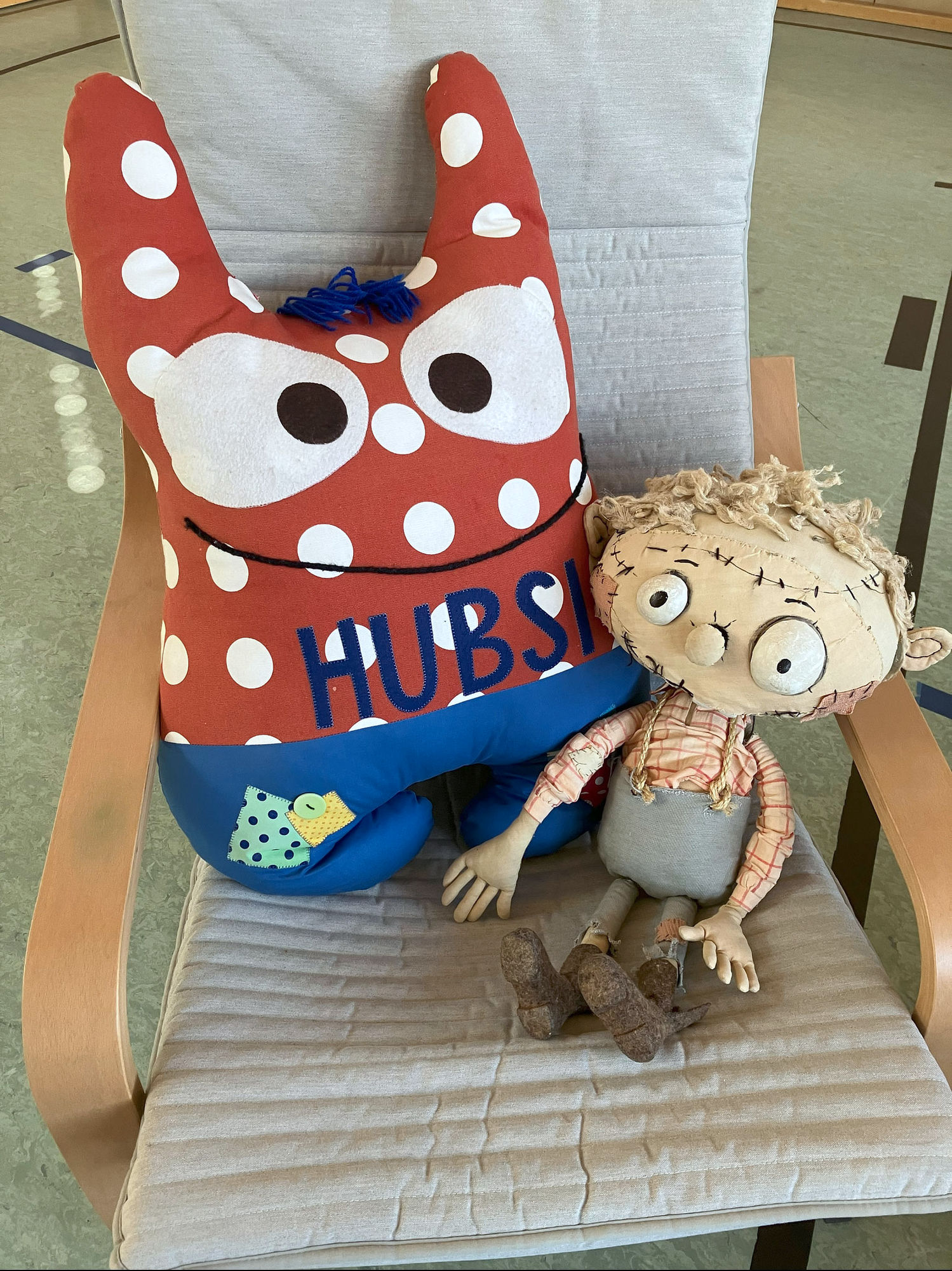 Schulmaskottchen Hubsi und Zombie-Puppe Zombert auf einem Sessel