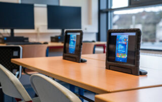 Zwei Tablets auf Tischen mit Stühlen im Klassenraum